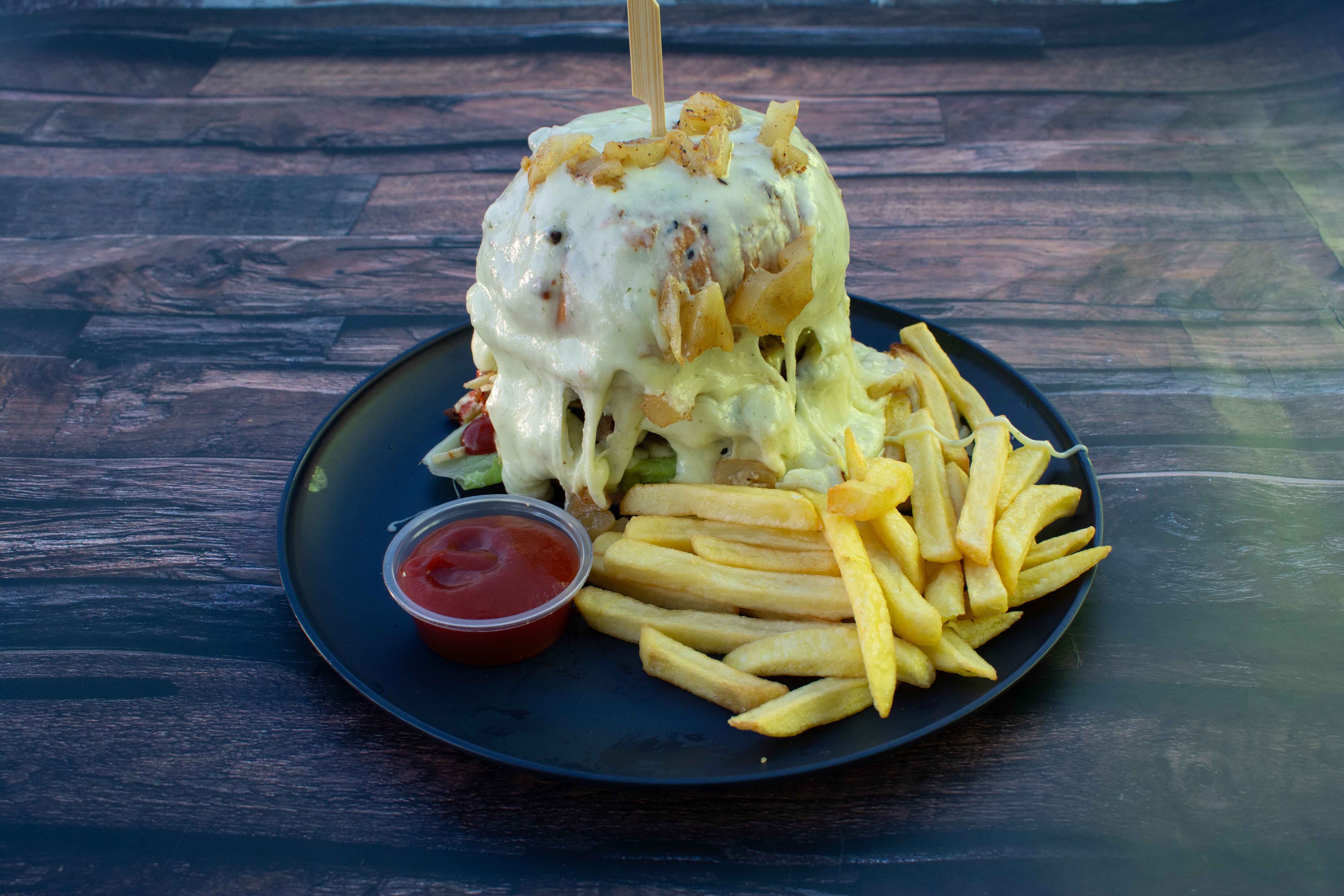 Hamburguesa Hawaiana bañada en queso derretido con papas a la francesa