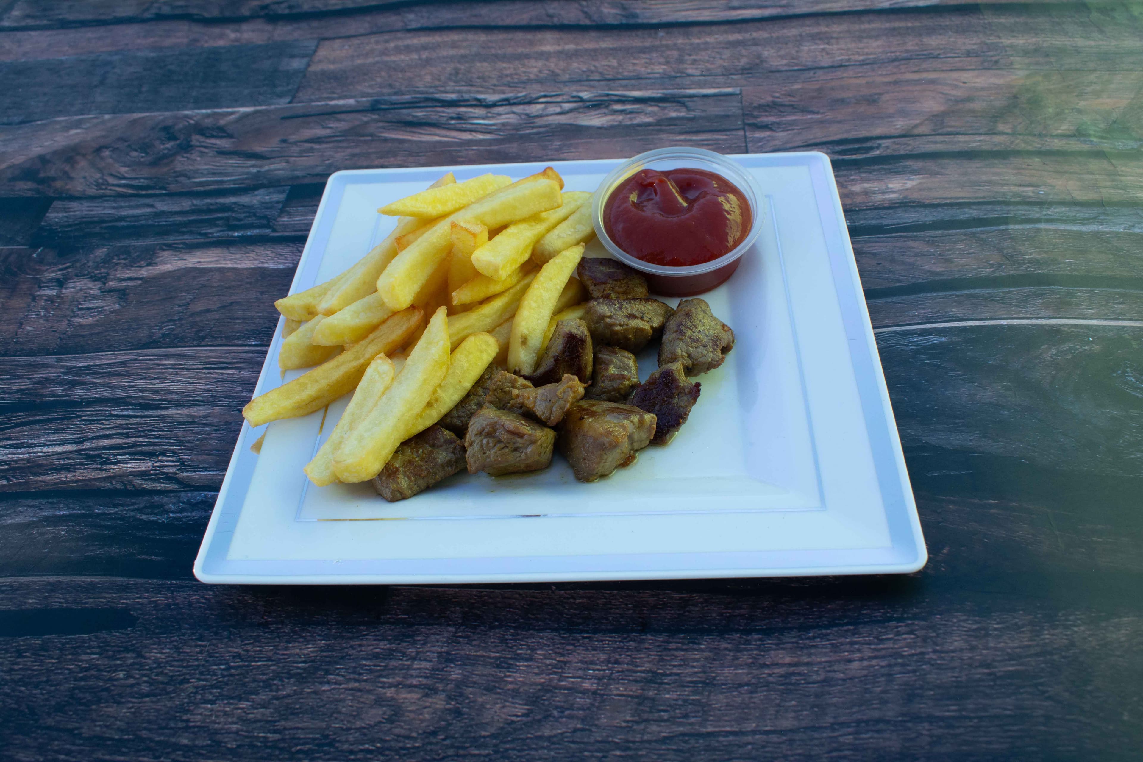 Papas a la francesa con trocitos de carne de res y ketchup