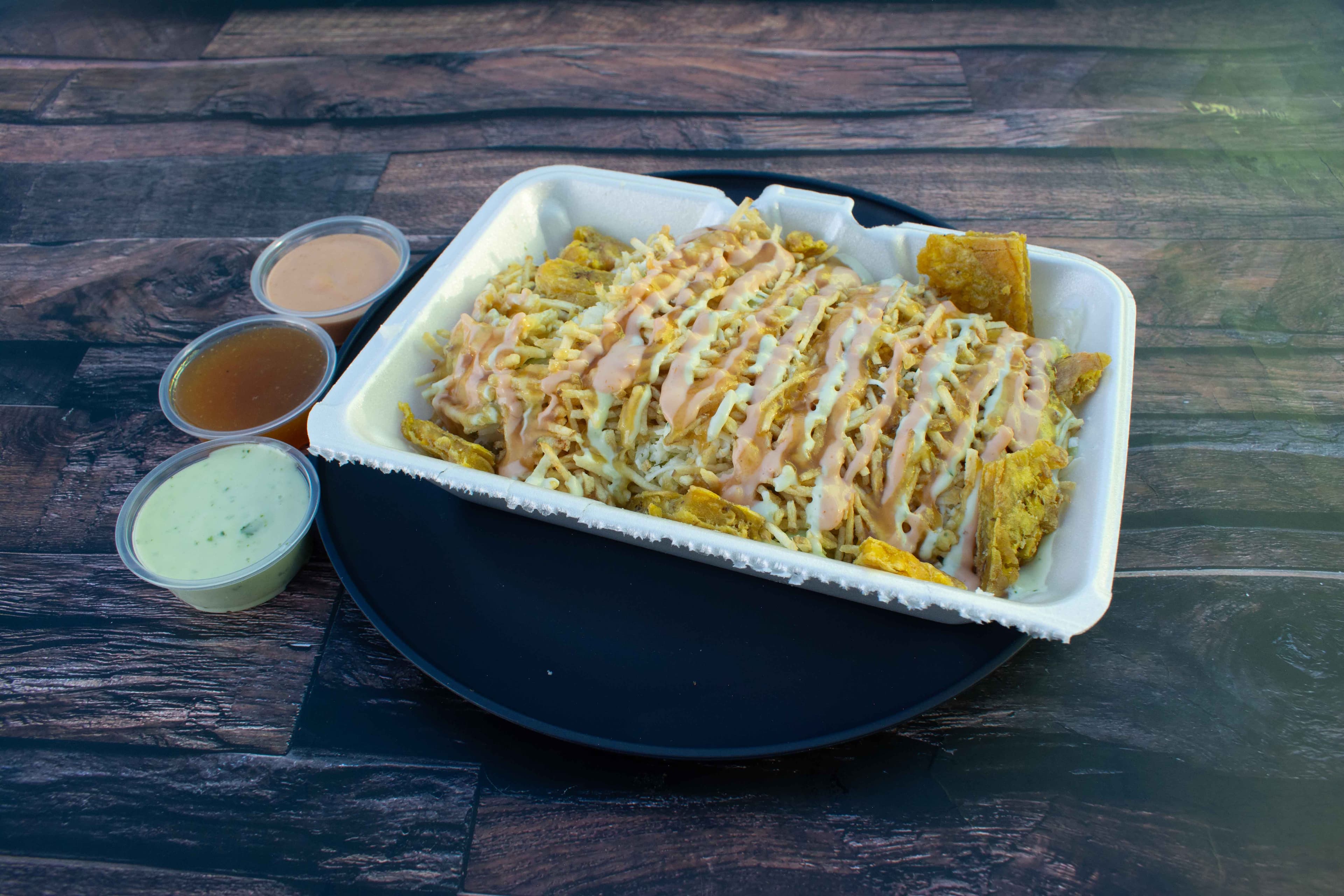 Patacón La Marimonda cargado de pollo, carne, queso y salsas