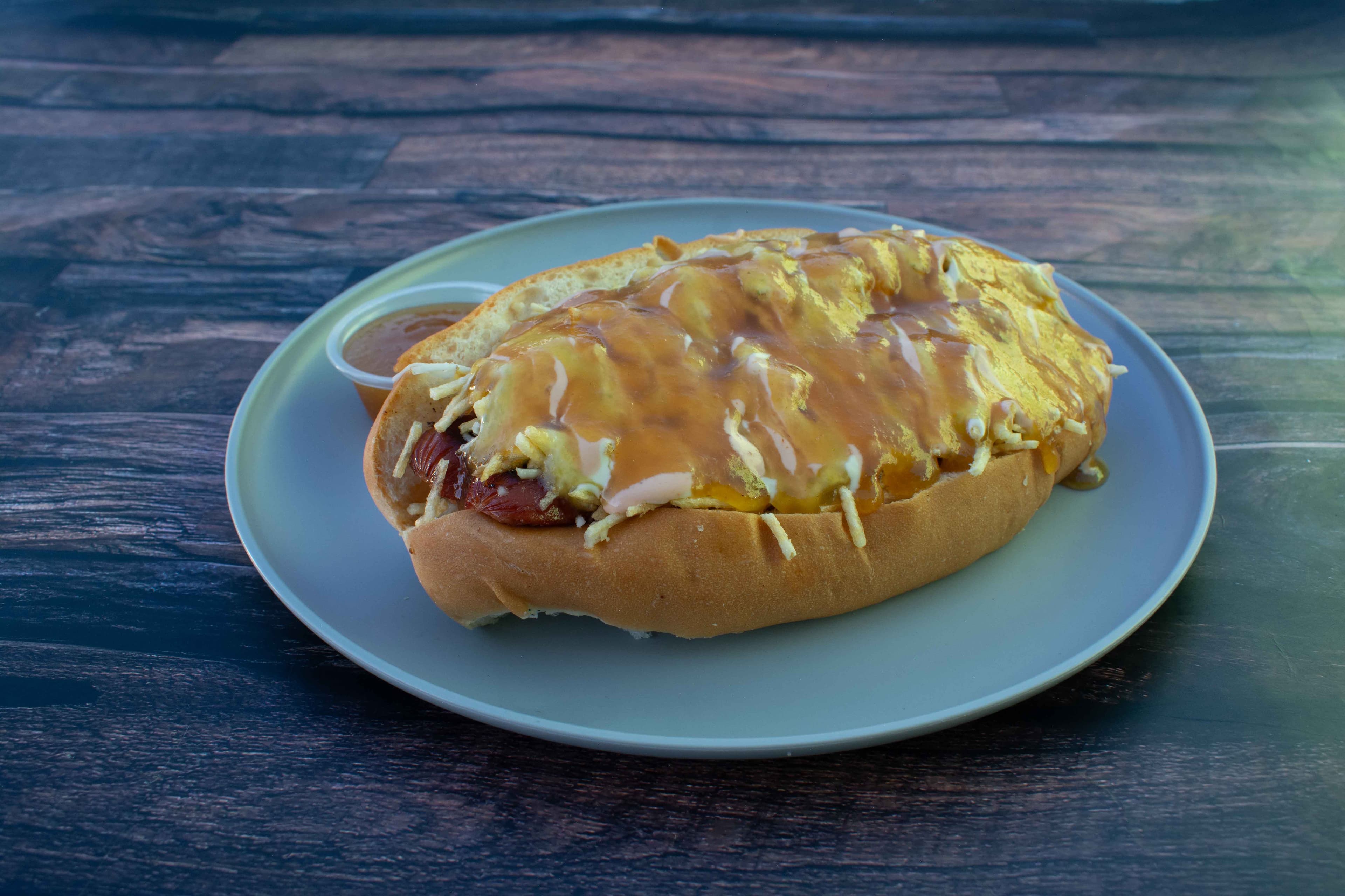Perro caliente hawaiano bañado en queso derretido y piña